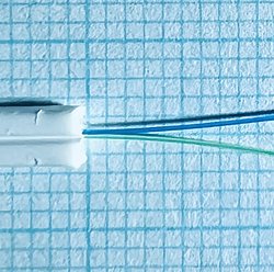 Abgemanteltes Glasfaserkabel vor Millimeterpapier